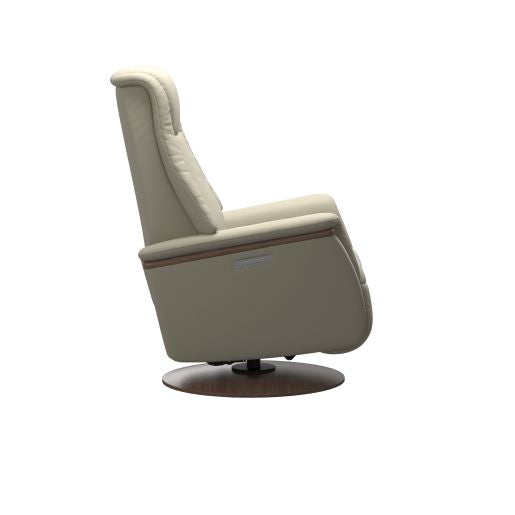 Side view light grey recliner chair with padded cushions and a round dark brown wood base 